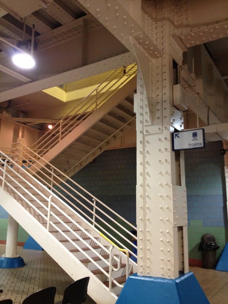 Now. Indianapolis Train Station reduced to a staircase in a 1960s-blue tiled waiting room in a Greyhound Bus Station.
